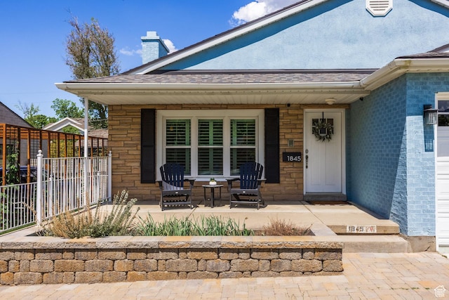 1845 E Princeton Ave, Salt Lake City, UT 84108 - property entrance with a porch, fence, a chimney, a shingled roof, and stone siding