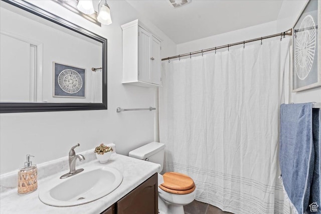 bathroom with toilet, vanity, and curtained shower
