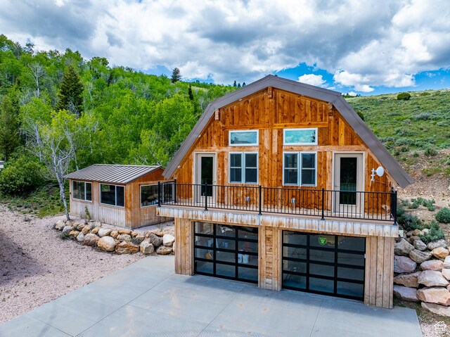 3431 S Panorama Dr, Garden City, UT 84028 - view of front of property featuring concrete driveway, an attached garage, and metal roof