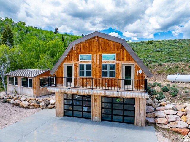 3431 S Panorama Dr, Garden City, UT 84028 - view of front of property featuring a garage, concrete driveway, and metal roof