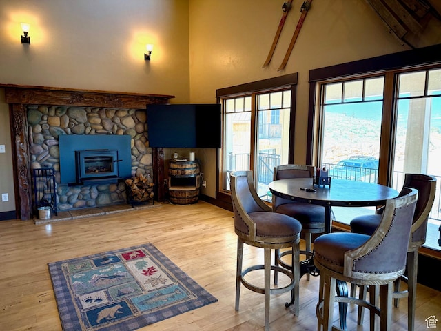3431 S Panorama Dr, Garden City, UT 84028 - dining room with light wood-style floors, high vaulted ceiling, baseboards, and a stone fireplace