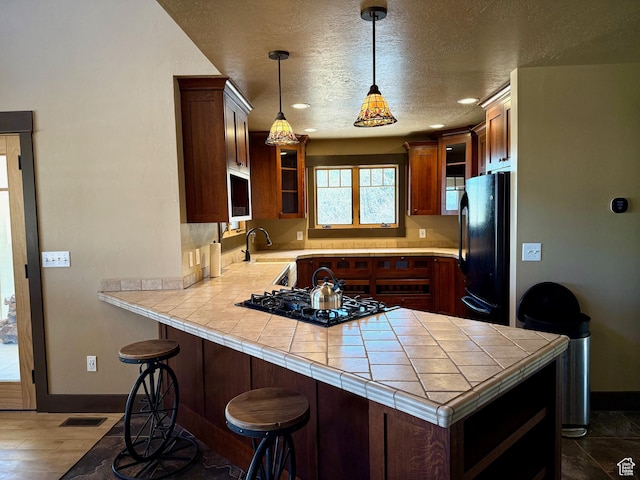3431 S Panorama Dr, Garden City, UT 84028 - kitchen with black appliances, a peninsula, glass insert cabinets, baseboards, and a sink