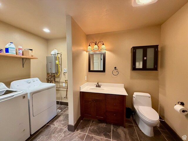 3431 S Panorama Dr, Garden City, UT 84028 - bathroom featuring washer and dryer, water heater, vanity, toilet, and baseboards