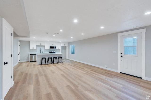 2571 N Geranium Dr W Unit 239, Saratoga Springs, UT 84045 - living area with baseboards, recessed lighting, light wood-style flooring, and healthy amount of natural light