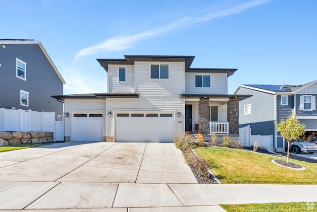 2571 N Geranium Dr W Unit 239, Saratoga Springs, UT 84045 - view of front of house with driveway, an attached garage, a porch, and stone siding