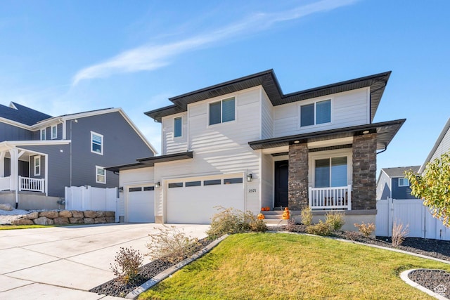 2571 N Geranium Dr W Unit 239, Saratoga Springs, UT 84045 - view of front of home featuring a porch, a garage, driveway, and stone siding