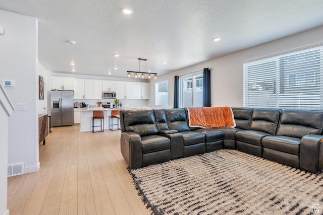 2571 N Geranium Dr W Unit 239, Saratoga Springs, UT 84045 - living room featuring plenty of natural light, light wood-style flooring, recessed lighting, and baseboards