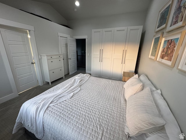 bedroom with dark carpet and lofted ceiling