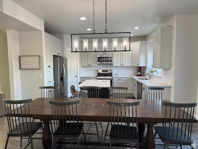 dining space featuring recessed lighting, wood finished floors, and baseboards