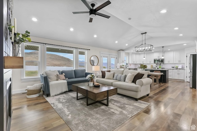 living room with lofted ceiling, a ceiling fan, light wood-style floors, and recessed lighting