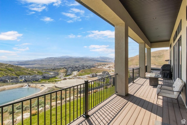 balcony with view of pool area, a mountain view, and area for grilling
