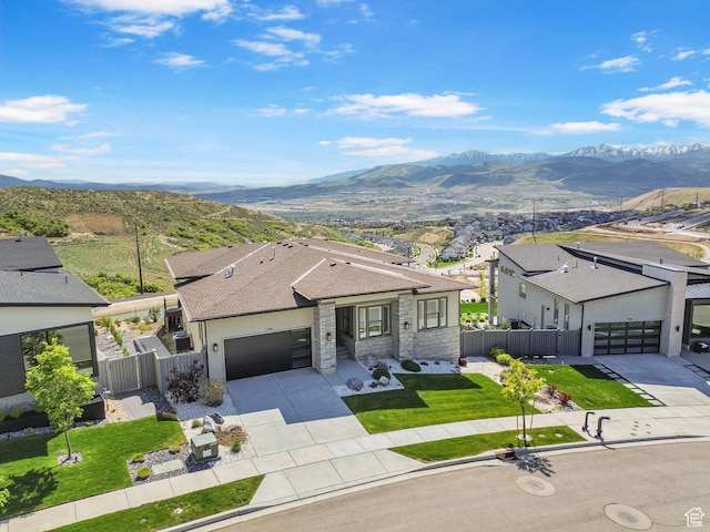 view of front of house with driveway, a mountain view, a garage, a shingled roof, and stucco siding