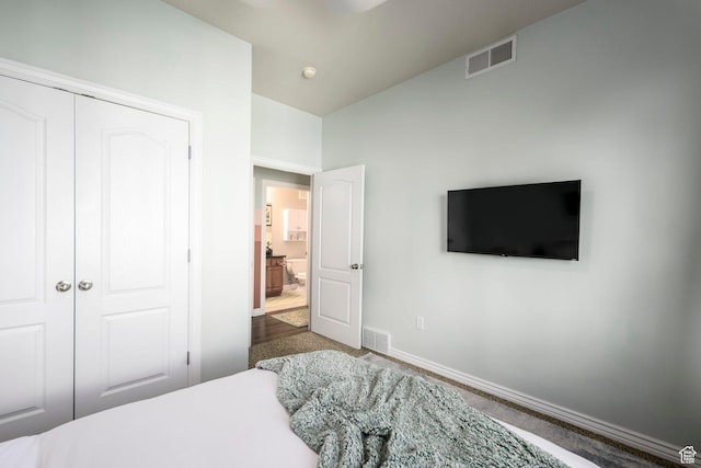 carpeted bedroom featuring baseboards and a closet