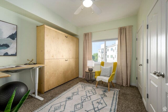 living area with a ceiling fan and baseboards