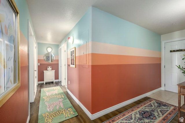 hall with wood finished floors and baseboards