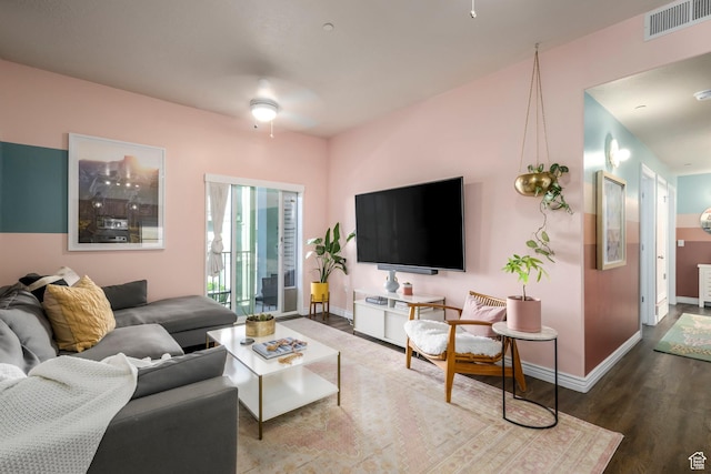 living room featuring wood finished floors, baseboards, and ceiling fan
