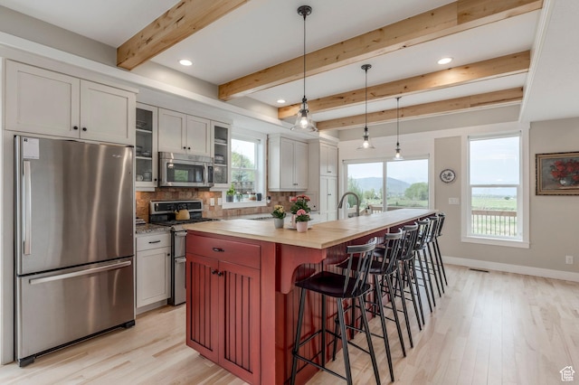 1920 S Wall St, Heber City, UT 84032 - kitchen with stainless steel appliances, wood counters, light wood-style flooring, decorative backsplash, and beamed ceiling