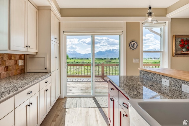1920 S Wall St, Heber City, UT 84032 - kitchen with light wood-type flooring, a mountain view, decorative backsplash, hanging light fixtures, and light stone counters