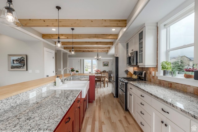 1920 S Wall St, Heber City, UT 84032 - kitchen featuring stainless steel appliances, a chandelier, light wood-type flooring, a sink, and decorative backsplash