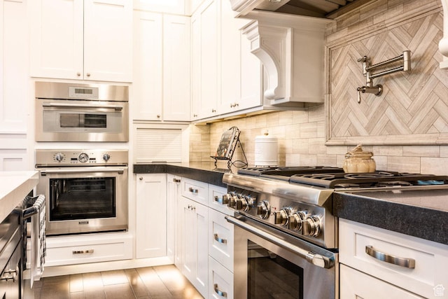 5314 W Rolling Brook Dr, Herriman, UT 84096 - kitchen featuring appliances with stainless steel finishes, dark countertops, decorative backsplash, and white cabinetry