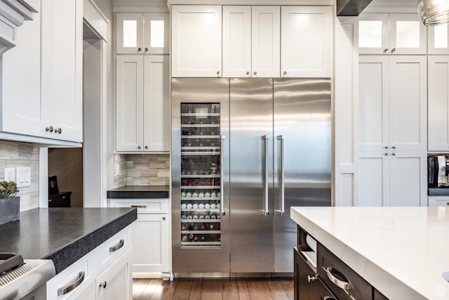 5314 W Rolling Brook Dr, Herriman, UT 84096 - kitchen featuring stainless steel built in refrigerator, tasteful backsplash, glass insert cabinets, white cabinetry, and dark wood-style flooring