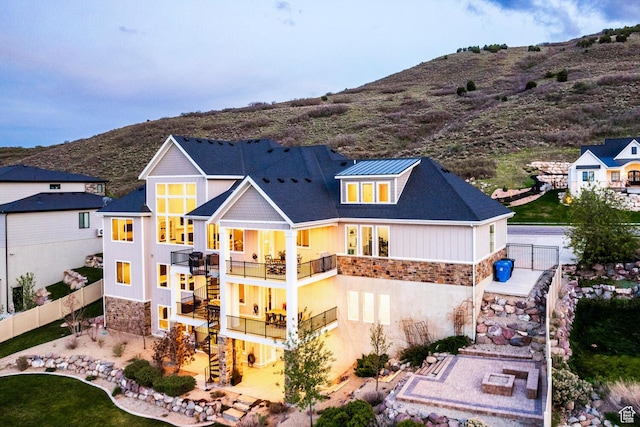5314 W Rolling Brook Dr, Herriman, UT 84096 - rear view of house featuring stairs, a balcony, stone siding, and fence