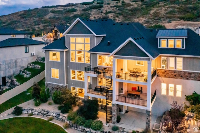 5314 W Rolling Brook Dr, Herriman, UT 84096 - rear view of house with a balcony, stone siding, fence, a mountain view, and a patio area