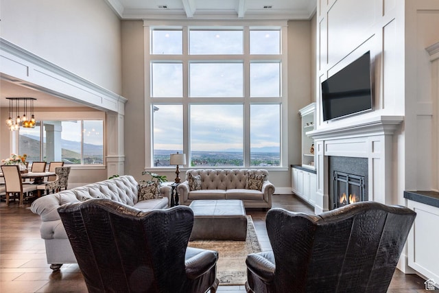 5314 W Rolling Brook Dr, Herriman, UT 84096 - living area featuring a towering ceiling, a lit fireplace, beam ceiling, a chandelier, and dark wood-type flooring