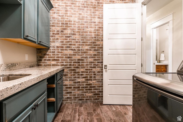 5314 W Rolling Brook Dr, Herriman, UT 84096 - kitchen featuring brick wall, light stone counters, dark wood finished floors, and stove
