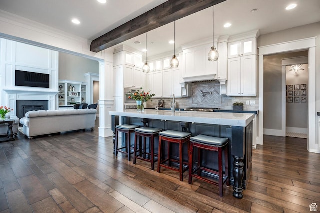 5314 W Rolling Brook Dr, Herriman, UT 84096 - kitchen featuring a kitchen breakfast bar, dark wood finished floors, glass insert cabinets, a sink, and recessed lighting