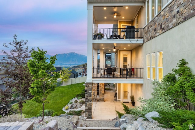 5314 W Rolling Brook Dr, Herriman, UT 84096 - back of property at dusk with a balcony, a patio, stucco siding, and a mountain view