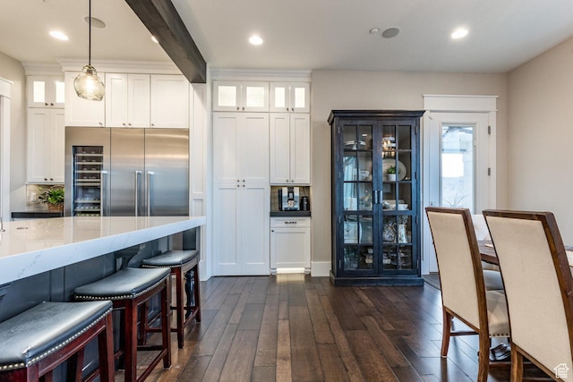 5314 W Rolling Brook Dr, Herriman, UT 84096 - kitchen featuring built in refrigerator, dark wood-style floors, white cabinets, glass insert cabinets, and hanging light fixtures