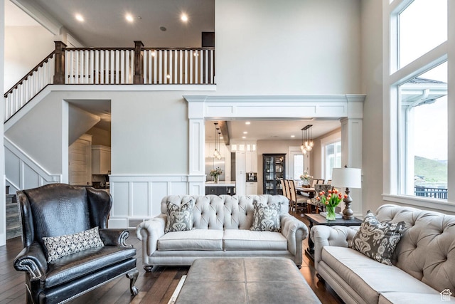 5314 W Rolling Brook Dr, Herriman, UT 84096 - living area with a towering ceiling, wood finished floors, a chandelier, a decorative wall, and stairs