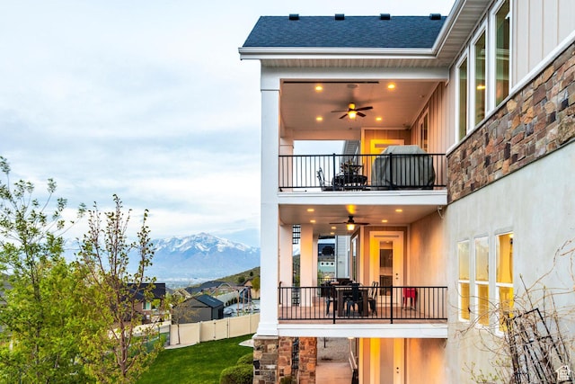 5314 W Rolling Brook Dr, Herriman, UT 84096 - back of house featuring a balcony, board and batten siding, a mountain view, ceiling fan, and a shingled roof