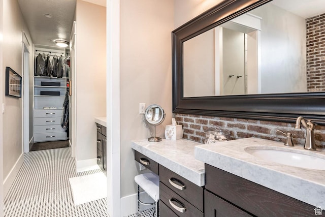 5314 W Rolling Brook Dr, Herriman, UT 84096 - full bathroom featuring vanity, a walk in closet, baseboards, and decorative backsplash