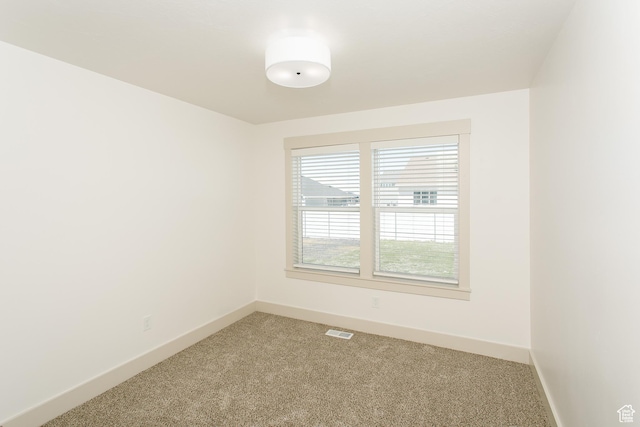 empty room with light colored carpet and baseboards