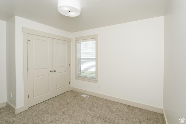 unfurnished bedroom with carpet floors, baseboards, and a closet
