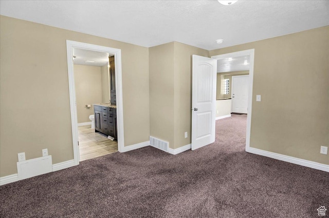 carpeted empty room featuring baseboards