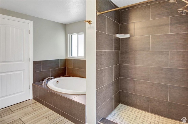 full bathroom featuring a tile shower and a garden tub