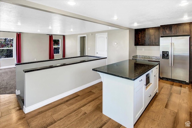 kitchen with stainless steel appliances, a kitchen island, light wood-style flooring, baseboards, and recessed lighting