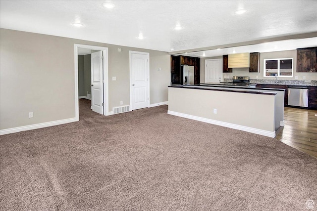 kitchen featuring appliances with stainless steel finishes, carpet, dark countertops, baseboards, and recessed lighting