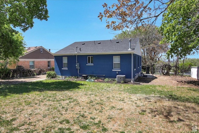 back of house with a lawn, central AC, and roof with shingles