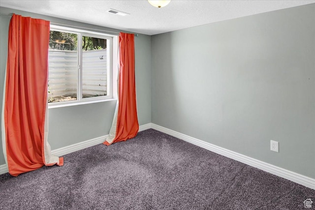empty room featuring carpet floors, baseboards, and a textured ceiling