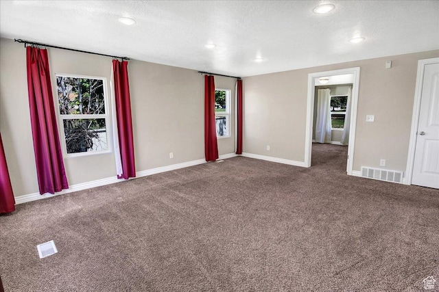 unfurnished room with carpet, plenty of natural light, baseboards, a textured ceiling, and recessed lighting