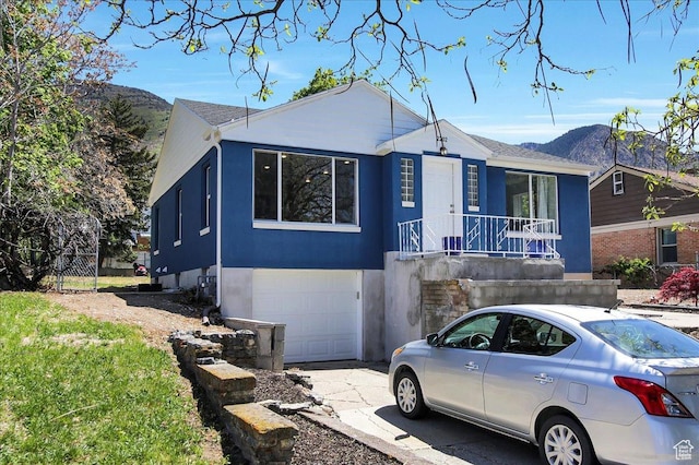 single story home featuring a garage, concrete driveway, a mountain view, and stucco siding