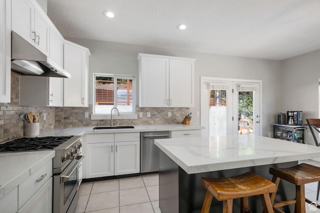 14038 S New Saddle Rd, Draper, UT 84020 - kitchen with a sink, appliances with stainless steel finishes, under cabinet range hood, decorative backsplash, and a textured ceiling