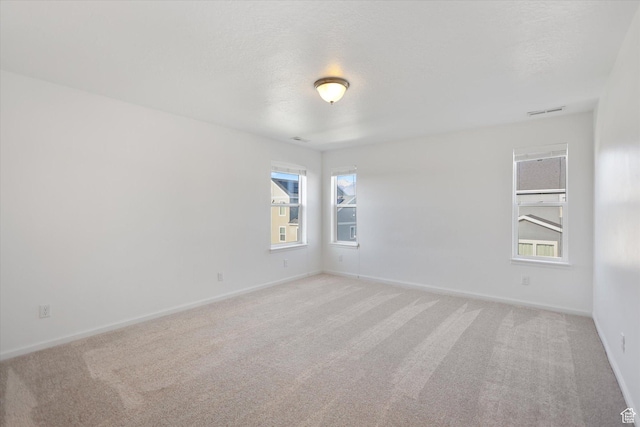 spare room with light carpet and baseboards