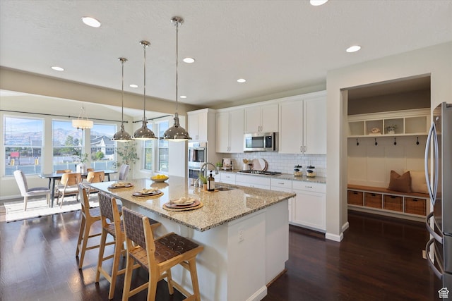 kitchen with stainless steel appliances, a sink, dark wood-style floors, tasteful backsplash, and recessed lighting