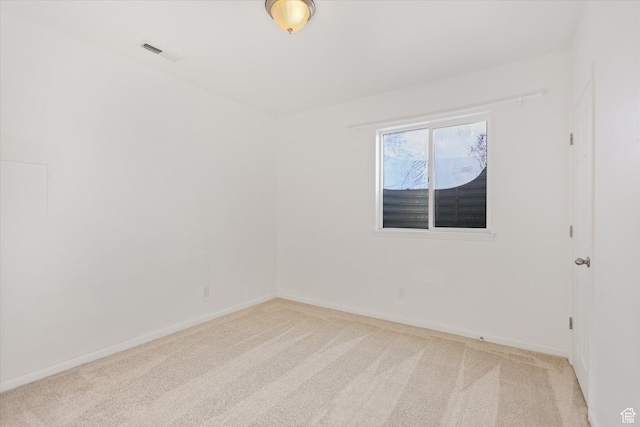 carpeted empty room featuring baseboards