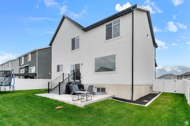 2607 N Mclaws Ave, Layton, UT 84040 - rear view of property with a trampoline, a patio area, a gate, and stucco siding
